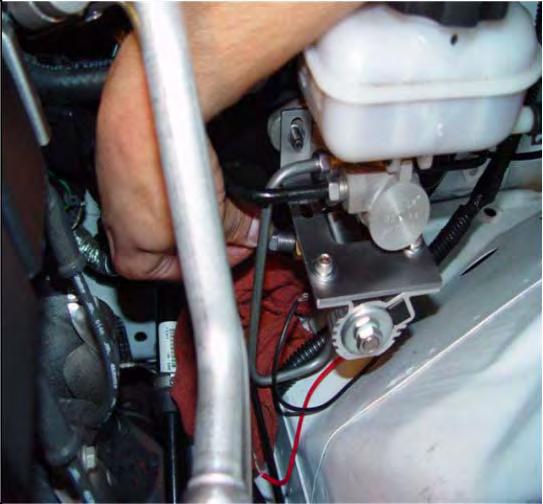 7. Install Hurst Roll Control system and bracket assembly. Recommended Installation Method: Push OEM brake line down to allow mounting bracket hole installation onto the Master Cylinder stud.