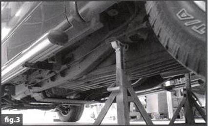 Support the vehicle with jack stands (FIG 3) on the frame rails in a secure location just forward of the front leaf spring