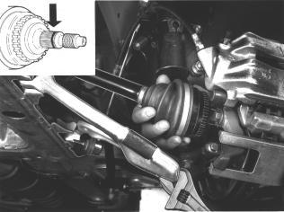 Apply metal adhesive, P/N 11613700, to the drive shaft splines as shown. Twist MacPherson strut clear and insert driveshaft in hub. Use a socket wrench to hold suspension arm down.