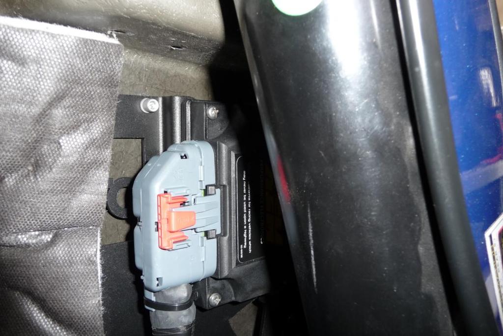 15. Slide the EMS bracket behind the roll bar and align the four holes to the drilled holes from the earlier step.