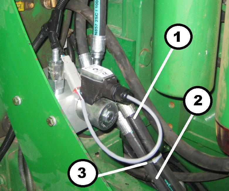 3.4.6 Hose Routing at Manifold Route the pressure hose across the frame cross member behind the hydraulic tank to the manifold at the left side of the engine compartment.