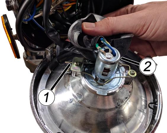 Move the rubber dust boot back to expose the bulb. 3. Unclip the headlight bulb (1) and replace with a 12V 35/35W bulb. 4.