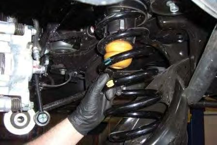 Make sure that the coil is properly seated in the lower control arm. Reinstall the shock.