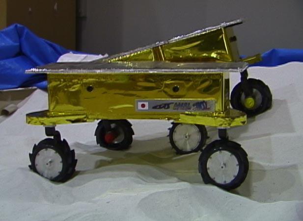 (a) The Micro5 rover prototype with PEGASUS system in a mobility test on silica sand the rocker-bogie has six wheels. Many wheels it has means many motors and gears are contained.