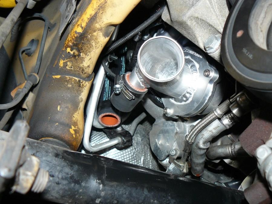 Step 10 Install the included short 1 silicone coupler onto the previously installed turbo outlet adapter by using a supplied 25-40 hose clamp, at arrow in Figure 9.