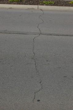 LONGITUDINAL AND TRANSVERSE CRACKING Longitudinal cracks are parallel to the pavement's centerline or laydown direction. They may be caused by: 1. A poorly constructed paving lane joint. 2.