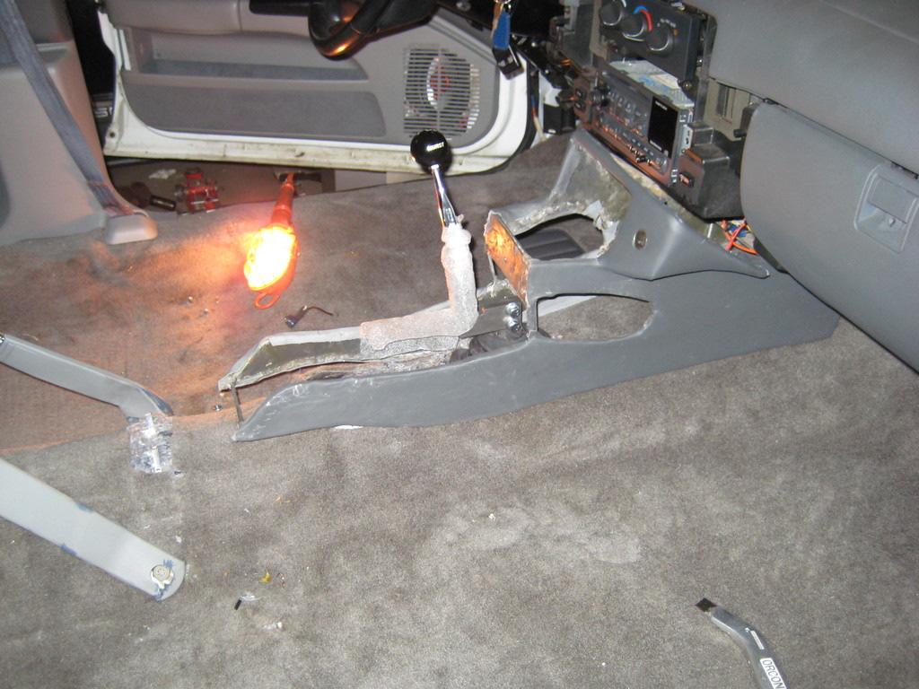 After this is complete lower car. 83. Now you need to reinstall the carpet over the shifter, you are going to have to trim the carpet to fit. 84.