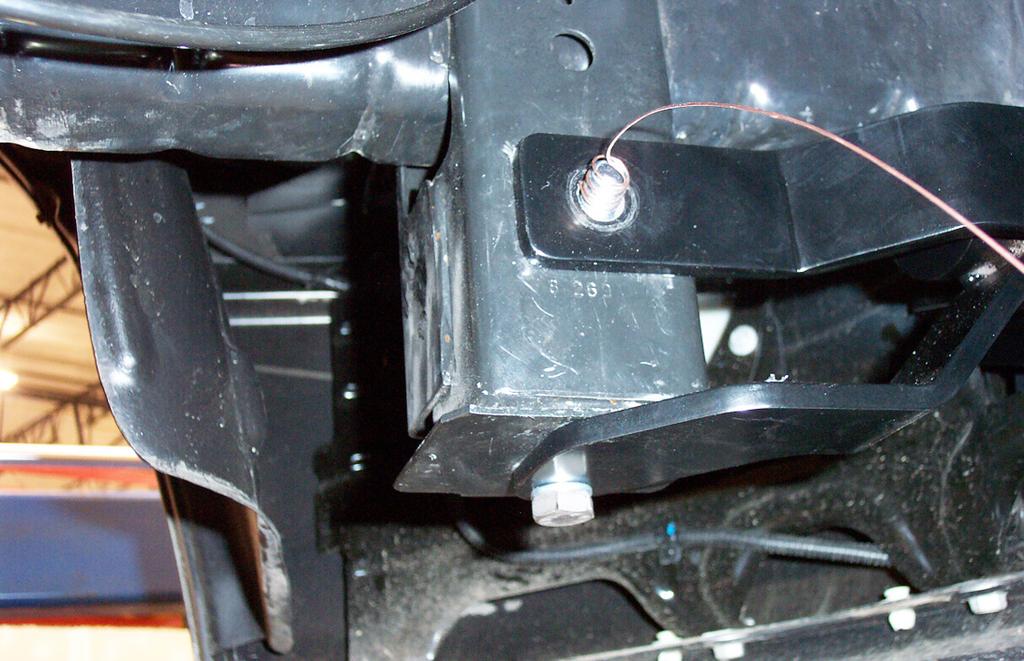 Then, working on the driver's side, fishwire a ¼" x 2" x 2" backing plate a ½" x 1½" carriage bolt through the gap between the frame the top rear of the tow hook support out the