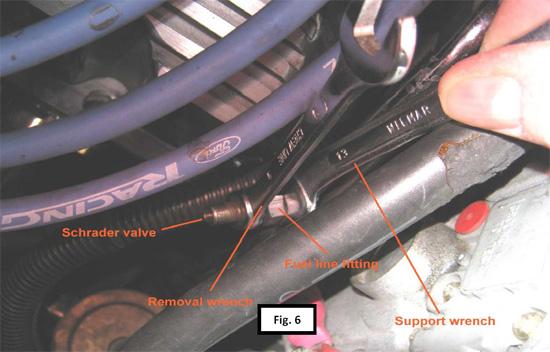 Remove the Schrader valve- Using the 13mm (or 1/2in.) open end wrench as a support for the fuel supply line fitting, remove the valve with the 9mm wrench. (See Fig. 6).