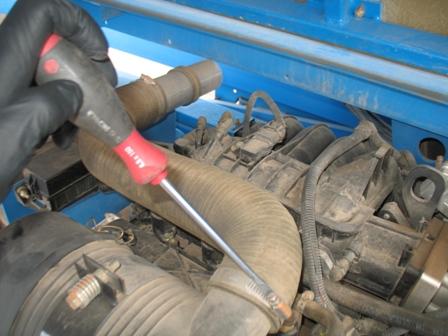START BY LOOSENING THE CLAMP AND SLIDING OFF THE AIR INTAKE HOSE FROM THE FILTER ASSEMBLY AS SEEN IN