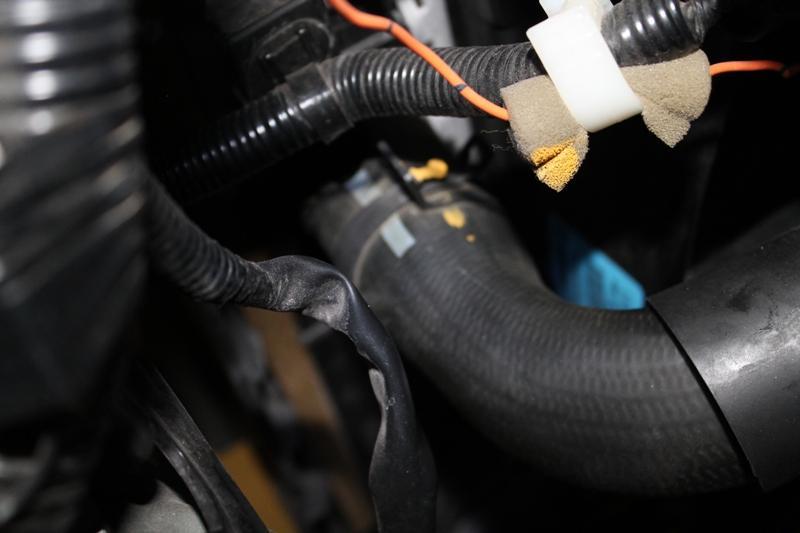 If the upper radiator hose is pushing down on the cold side intercooler hose, loosen the clamp and