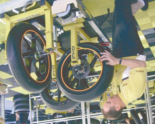 A typical scene at race meeting. A tyre technician is balancing a wheel statically. The relative narrowness of such wheels does not often allow for significant dynamic imbalance.