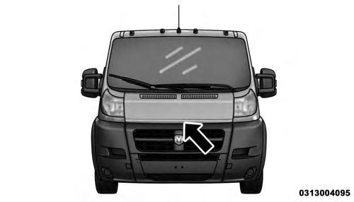 2. Move to the outside of the vehicle, reach into the opening beneath the center of the hood