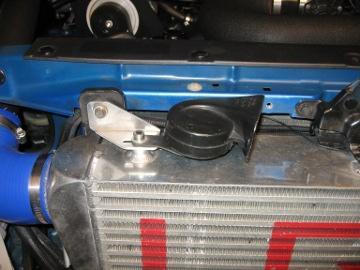 H. Bend the lower tab on the hood latch forward to a 90 degree angle. Attach that tab to the intercooler threaded mount using an M8x1.25x10mm socket headed cap screw and 8mm washer.