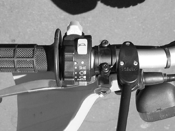 14. Turn Signal Switch Installation: Install the turn signal switch on the left handlebar next to the grip as shown in Photo 11. The switch has a single screw that pinches it together on one side.