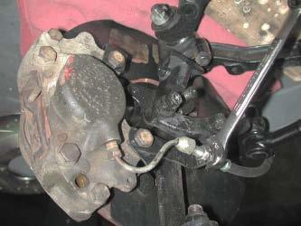 caliper mounting bolts. Remove the bottom bolt.