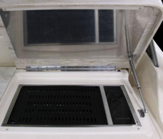 The optional grill installs in the top of the wet bar, and notice that Grady White uses a heat shield on the underside of the hatch and an automatic shutoff switch next to the gas strut base.