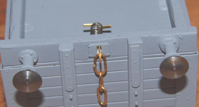 Now push the spring (part 7) over the back of the back of the coupling hook and bend the tags over to secure the