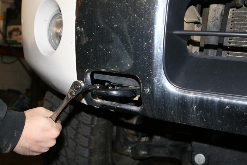 D. Using a 14mm socket and extension remove the bolt located inside the tow hook area on either side. E.