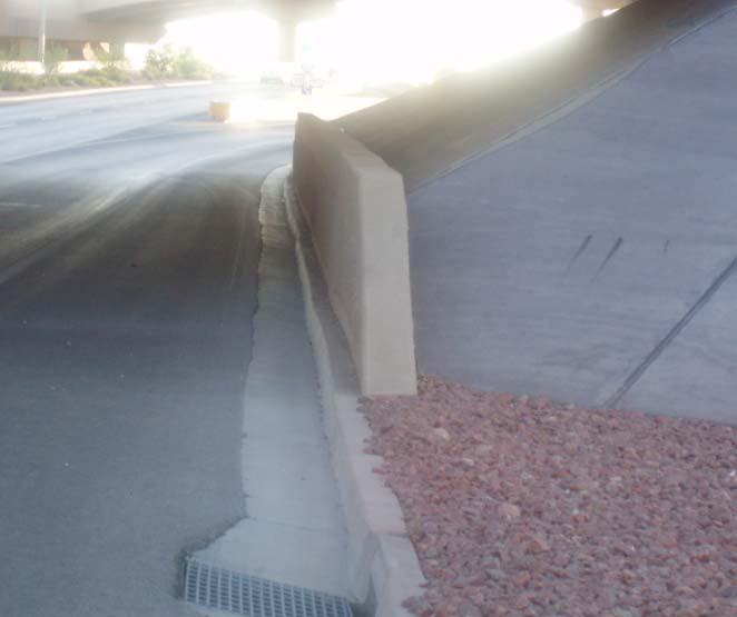The concrete barrier at the abutment of the bridge structure as shown in Photo 8 is next to the existing concrete curb.