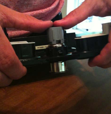 -Using a small flat head screwdriver, pry the locking tabs away from the plastic ring. (Figure 15).