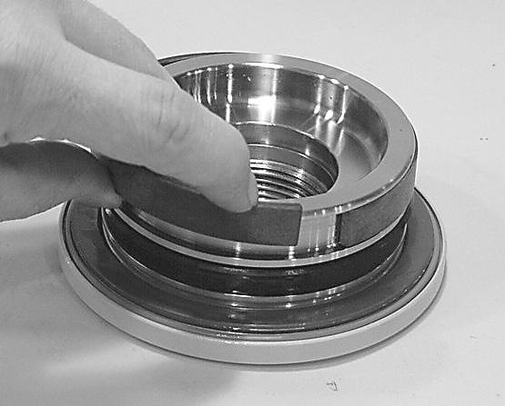 Install the outer T-seal (202) by stretching it around the groove in a circular motion.