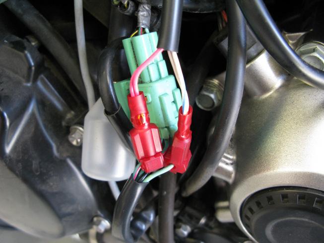 3. Locate the green gear position sensor (GPS) connectors found just behind the stator cover. Separate the green/red wire of the GPS connector from the rest.