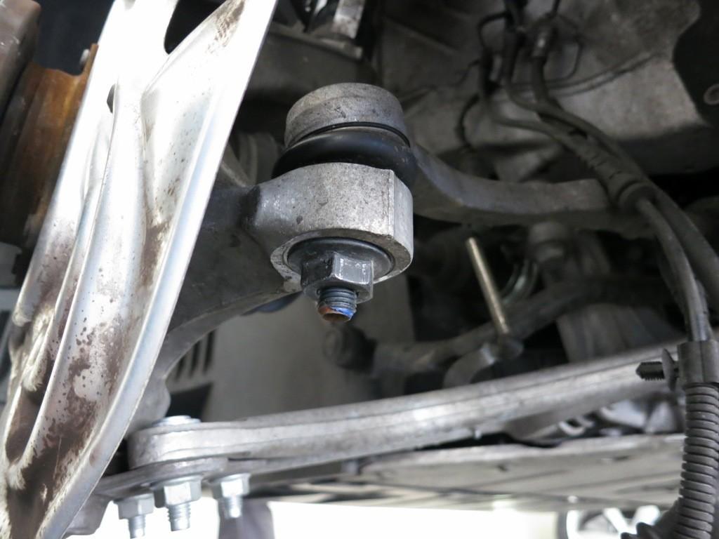 Step 12 (Front): Disconnect the tie rod end While holding the center of the tie rod end stud with a hex key, loosen the 21mm nut holding the tie rod in place until it extends just beyond the end of