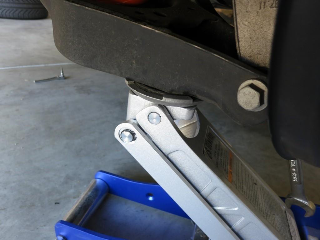 Step 4 (Rear): Lower rear spring arm Support the rear spring arm with a floor jack.