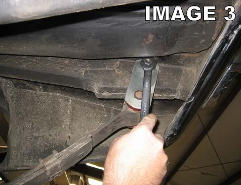 Using a 5/8 socket, loosen and remove the rear leaf spring shackle bolts.