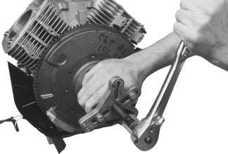 flange screw securing the flywheel to the crankshaft. See Figure 9-57. NOTE: Always use a flywheel strap wrench or holding tool to hold the flywheel when loosening or tightening the flywheel screw.