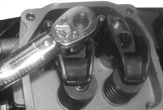 Apply grease to the contact surfaces of the rocker arms and rocker arm pivots. Install the rocker arms and rocker arm pivots on one cylinder head, and start the two hex. flange screws.