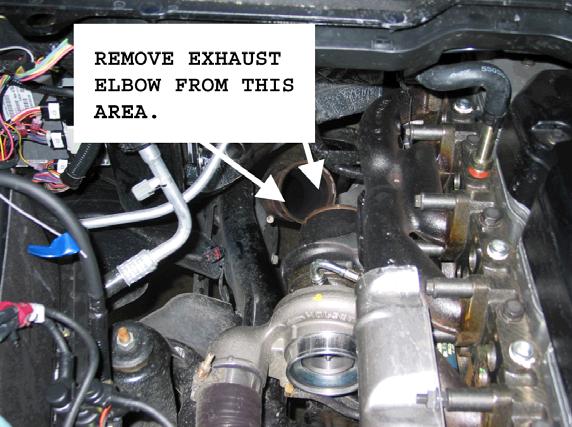 From underneath the vehicle, remove the down pipe-to-turbo elbow band clamp using a 10mm socket.
