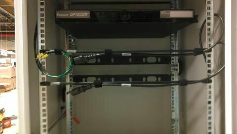 Figure 20: Horizontal support bar with ground cables and labeled AC power cords. 49. Attach the power cord in the rear of the enclosure shown in Figure 20.