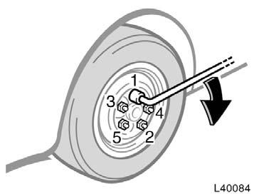 Lower the vehicle completely and tighten the wheel nuts. Turn the jack handle counterclockwise to lower the vehicle. Use only the wheel nut wrench to tighten the nuts.