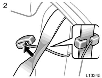 2. Pinch the two edges of the shoulder belt for the rear seat outside position with your fingers and slide the belt past the slot of the guide as