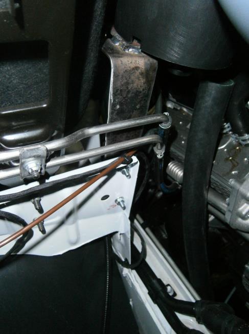 Install the compressor air filter bracket in the engine bay behind the radiator overflow bottle.