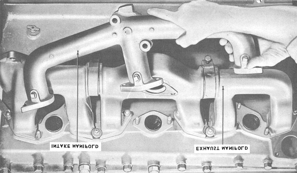 Figure 12-11. Intake and exhaust manifolds. matching those of the cylinder block, that allow the cooling water to circulate in the head. The head also helps keep compression in the cylinders.