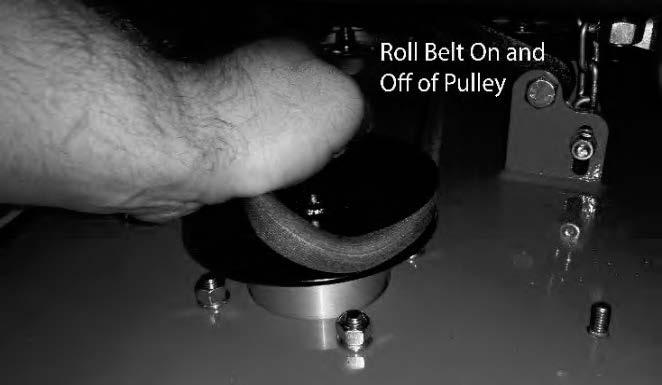 While lifting up on the belt (as shown in the photograph), rotate the pulley until the belt is free of the