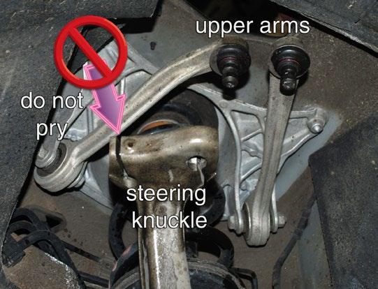 Do NOT insert a chisel or any other prying device into the machined gaps where the arms enter the knuckle or you will damage the knuckle (arrow).