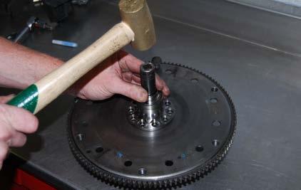 Step 4: Turn the drive plate over and once again support the center bolt flange using a large socket or suitable tool.