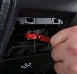 WHAT TO DO IN EMERGENCIES While holding the locking tab in the disengaged position, pull the tether strap to rotate the lever rearward, until it locks in place pointing towards the driver's seat.