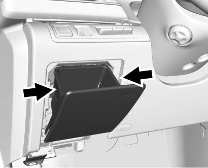 VEHICLE CARE 355 Apply pressure to the two retaining tabs on the sides of the compartment, until the two retaining tabs clear the sides of the