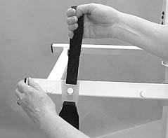 Grasp the pull loop with one hand, hold the spreader bar steady with your other hand, and pull the loop up to slide the large end of the keyhole tang over the post (Figure 14). 2.