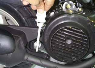 Place an oil pan under the motorcycle, and remove oil strainer cap. Make sure if the aluminum washer of the draining bolt is damaged. If so, replace it with new one.
