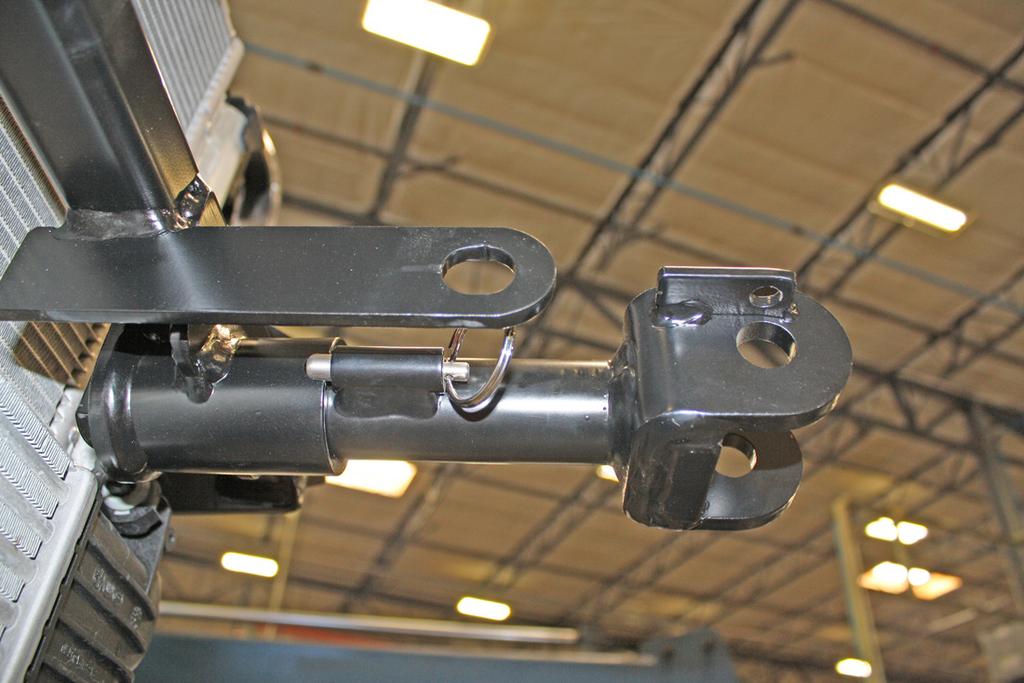 On each side, insert the removable front bracket arm into the front receiver 90 degrees from its final towing position, depressing the spring-loaded