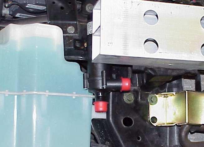 Slide the OEM bracket off the bottle and attach the supplied mounting bracket to the reservoir. Mount the reservoir in the spot forward of the left wheel well as shown in Figure 35.