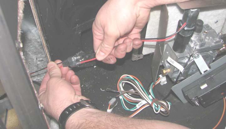 12. Reach in behind the valve assembly and disconnect the DCMD (red and black) wires leading from the gas control valve to the battery box.