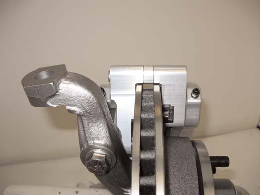 Slide the caliper over the rotor and secure it to the bracket using the