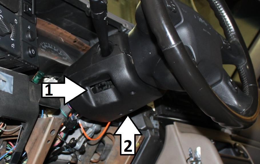 Remove the tilt lever from the steering column (1) and the screws from the bottom